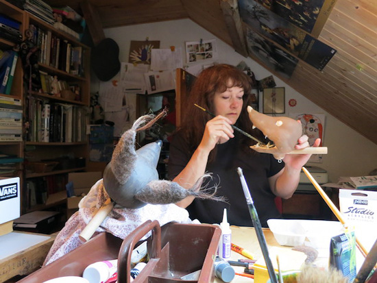Capucine Mazille en train de peindre les marionnettes du spectacle
